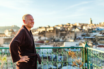 Man on the rooftop enjoying view of Fez old arabic medina, Morocco, Africa