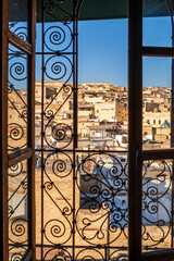 Fez medina seen through riad's window with decorative grate, Morocco, Africa