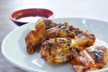 roasted chop chicken wing on plate dipping with spicy sauce