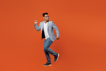 Full body side view happy young employee business man corporate lawyer wear classic formal grey suit shirt glasses work in office run away look aside isolated on plain red orange background studio.