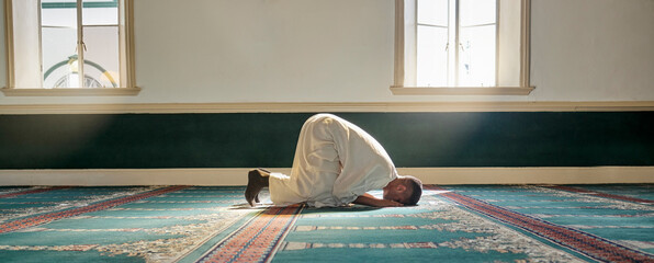 Mosque, worship and muslim man in prayer on his knees for gratitude, support or ramadan for...