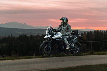 Motorcycle rider in mountains during sunset