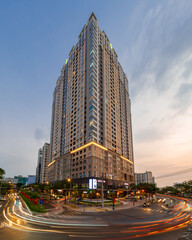 Obraz premium HOCHIMINH CITY, VIETNAM - JANUARY 19, 2022: Blue hour in District 4, Novaland residential building lights up in the late afternoon, with a beautiful sunset sky. 