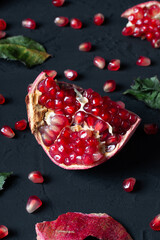 Ripe red pomegranate with fresh juicy seeds on a dark background. Natural vitamins. Healthy food concept. Food background. 