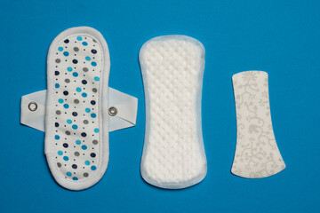 Three types of period pads, on blue background.