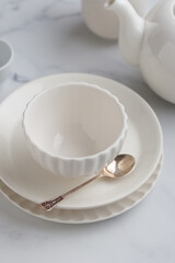 Empty tableware - white plate, a bowl and a cup on white table as a background for a dish foodbackground