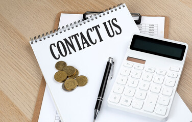CONTACT US text on a notebook with chart and calculator and coins, business concept