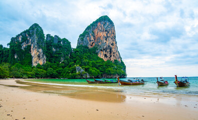 Fototapeta premium Long tail boats at Railay beach, Krabi, Thailand. Tropical paradise, turquoise water and white sand.