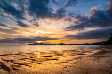 Beautiful sunset with dramatic clouds and sky of blue and orange color. Ao Nang beach, Krabi town, Thailand.