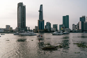 HOCHIMINH CITY, VIETNAM - JANUARY 22, 2022: sunset afternoon looking over district 1 ho chi minh city with Bitexco building and other high-rise buildings. There are cruise ships on the river