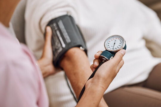Blood pressure, hypertension and nurse with patient to check diabetes, healthcare consulting and service in clinic. Closeup hands of woman doctor measure arm pulse, medical test and heart wellness