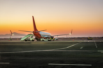 Preparation of the airplane before flight. Airport at the colorful sunrise