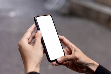 cell phone blank white screen mockup.hand holding texting using mobile on desk at office.background...
