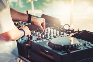 DJ is mixing music with deejay controller at outdoor summer pool party - nightlife people lifestyle...