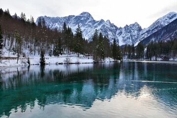 Scenic view of lago di fusine inferiore near Tarvisio in Friuli-Venezia Giulia region of Italy and Mangart mountain in Julian alps in winter