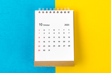 The October 2023 Monthly desk calendar for 2023 year on blue and yellow background.