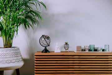 Scandinavian home interior with decorative accessories standing on a wooden cabinet. Minimalist...