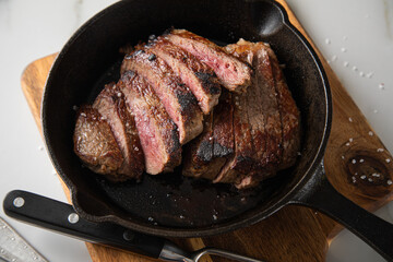 Entrecote Steak vom Rind medium rare gebraten in Gusseisen Pfanne mit Meersalz auf Holzbrett mit...