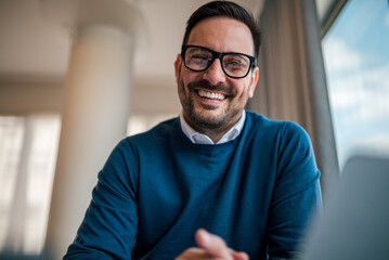 Portrait of delighted handsome employee, posing for the camera in the office.