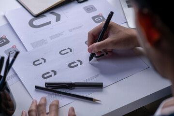 Graphic designer drawing sketches logo design. The concept of a new brand. Professional creative...