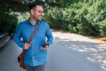 Smiling young adult entrepreneur man, looking away, enjoying the nature.