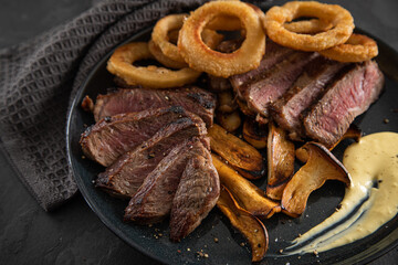 Entrecote Steak vom Rind medium rare gebraten mit Zwiebelringe, Pommes und Sauce Hollandaise auf...