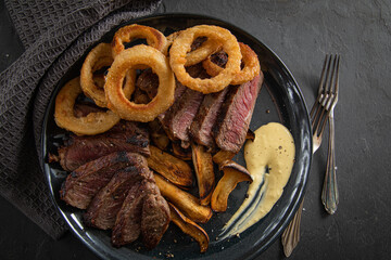 Entrecote Steak vom Rind medium rare gebraten mit Zwiebelringe, Pommes und Sauce Hollandaise auf...