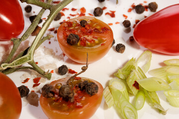 different colored tomatoes with salt peppercorn on a white plate