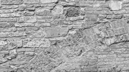 Old grungy clear retro brick wall of ancient city. Uneven soft pitted peeled surface brickwork of cellar worn. Ruined solid bumpy stiff blocks. Hard simple ragged holes brickwall for 3D grunge design