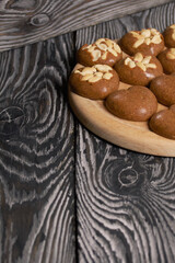 Homemade caramel. Brown caramel candies. Creamy sweets with peanuts. On pine boards.