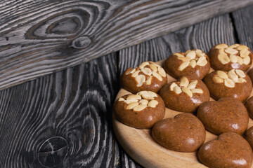 Homemade caramel. Brown caramel candies. Creamy sweets with peanuts. On pine boards.