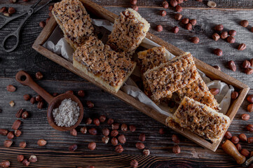 Nut cake with caramelized hazelnuts on wooden background. Flat lay