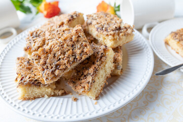 Plate with slices of hazelnut cake on white background