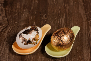 two eggs with golden structures on a table