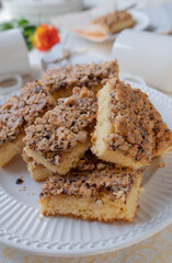 Sheet sponge cake with crunchy hazelnut topping on a white table
