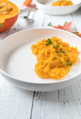 Squash puree served for side dish on a plate on white background.