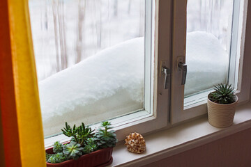 Windowsill with big snowdrift on winter day