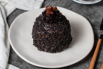 Chocolate and pistachio cake on a dark background. Delicious cake with cream filling. Studio shoot. Bakery products. close up