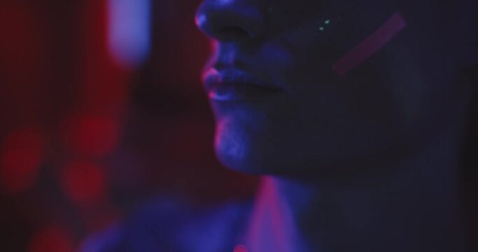 Close up lips of a young man in makeup in blue lights