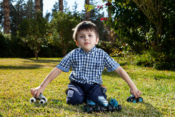Boy is playing a cars multitrack on the garden 