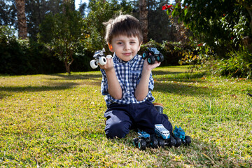 Boy is playing a cars multitrack on the garden 
