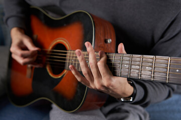 Fototapeta na wymiar Young man playing guitar at home