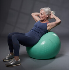 Senior woman working out with a gym ball