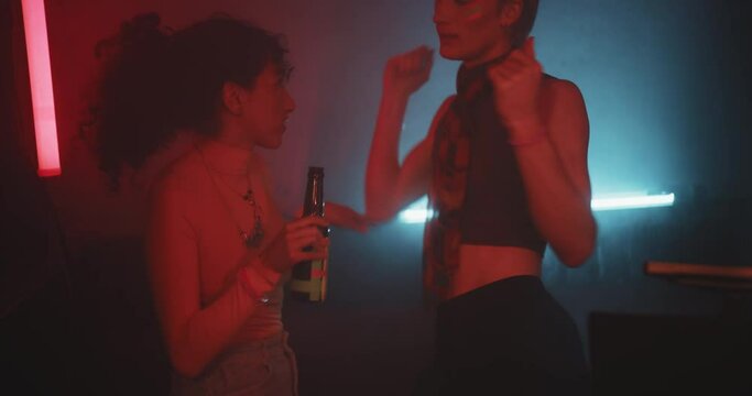 Group of three young friends talking and smiling in a bar 