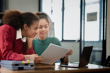 Two American women are working together in the office of a startup company. They are having a brainstorming and planning meeting in a joint department, women leading the way. Concept of women's work.