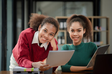 Two American women are working together in the office of a startup company. They are having a brainstorming and planning meeting in a joint department, women leading the way. Concept of women's work.