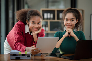 Two American women are working together in the office of a startup company. They are having a brainstorming and planning meeting in a joint department, women leading the way. Concept of women's work.