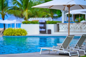 White sand beach and blue sea landscape view of a tropical resort hotel beside modern swimming...