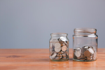 Save money concept for Finance Banking Business Idea with money in a glass jar on wooden table with filter effect retro vintage style. Investments, Funds, Bonds, Dividends and Interest.
