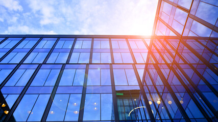 Glass modern building with blue sky background. Low angle view and architecture details. Urban...